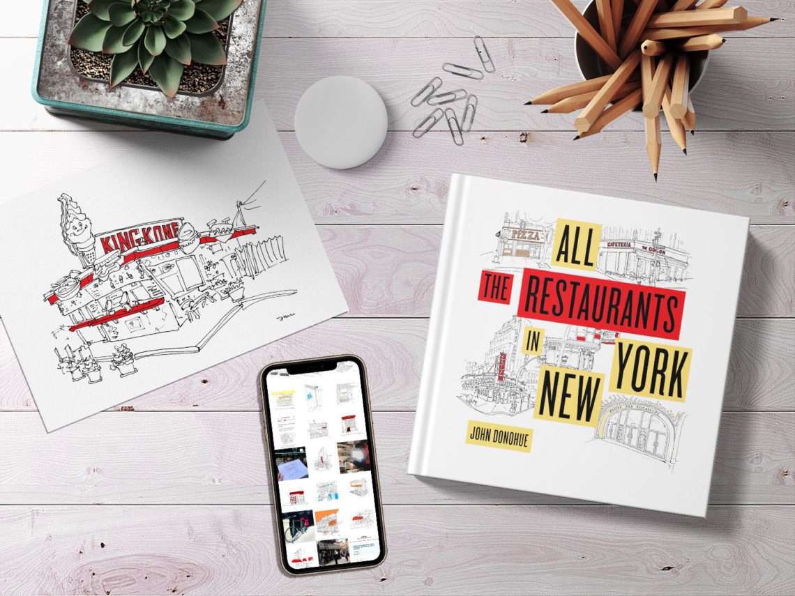 Wooden desktop with a plant, an art print, an iphone, a book, and a cup of pencils